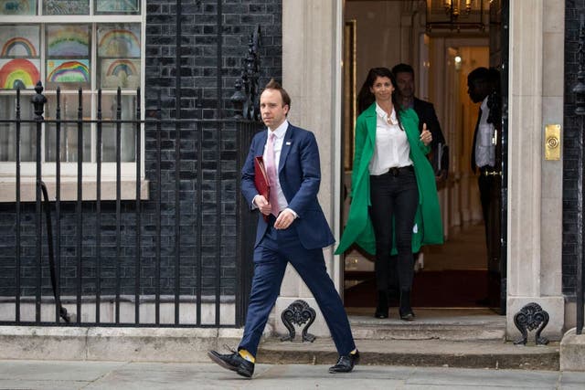 <p>Matt Hancock leaves 10 Downing Street after the daily press briefing in May, with Gina Colandangelo in the green coat</p>