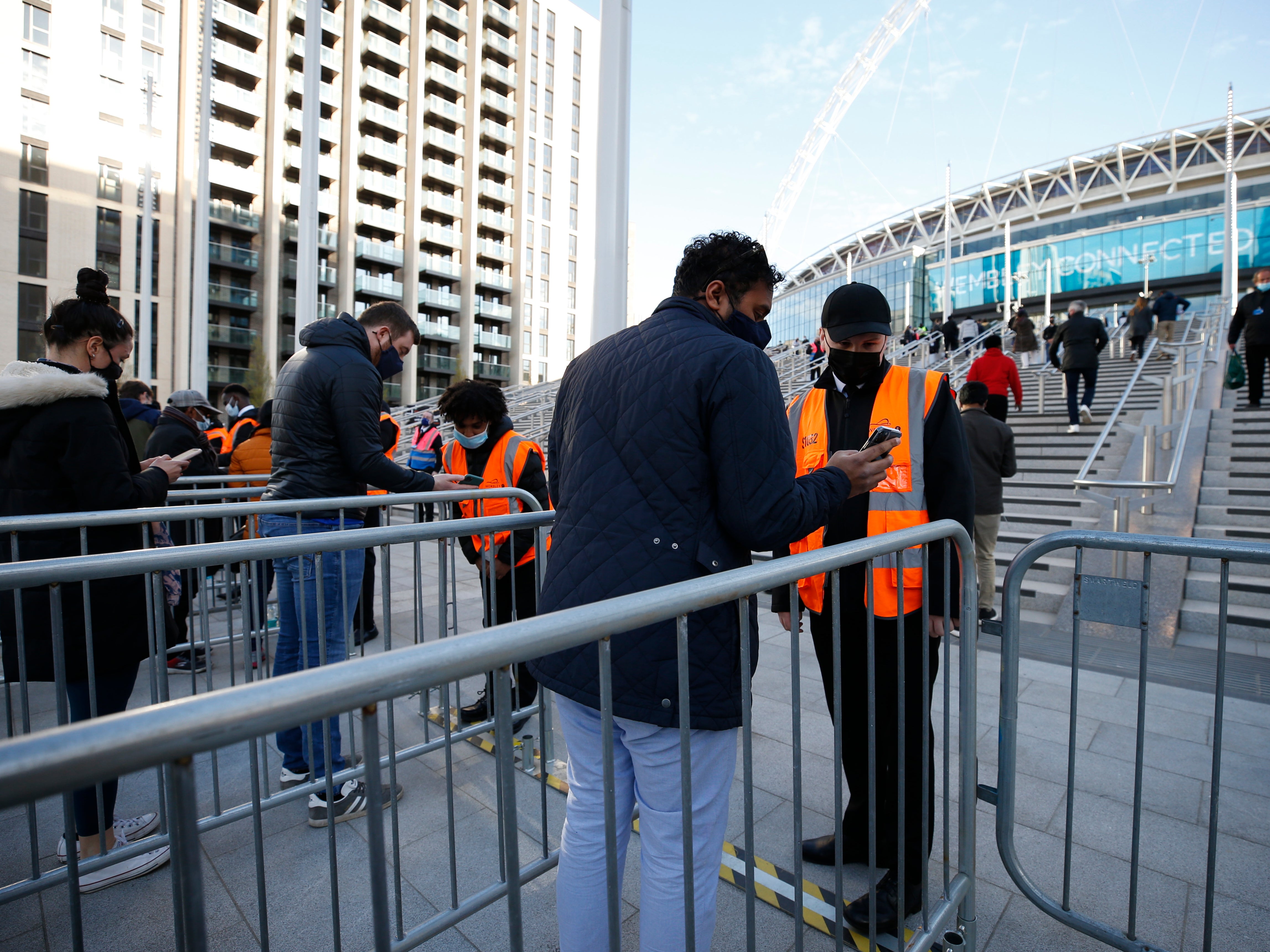Football fans show their negative Covid-19 test results in order to enter Wembley Stadium for the FA Cup final