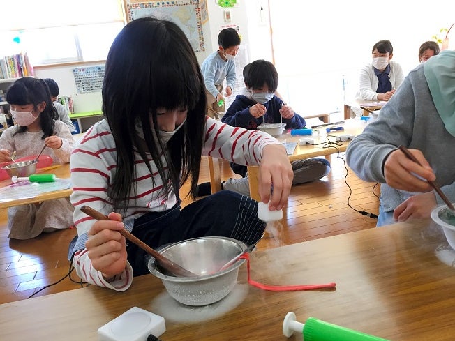 Children are involved in an experiment using liquid nitrogen at the Poppins After-School care center of Nagoya University