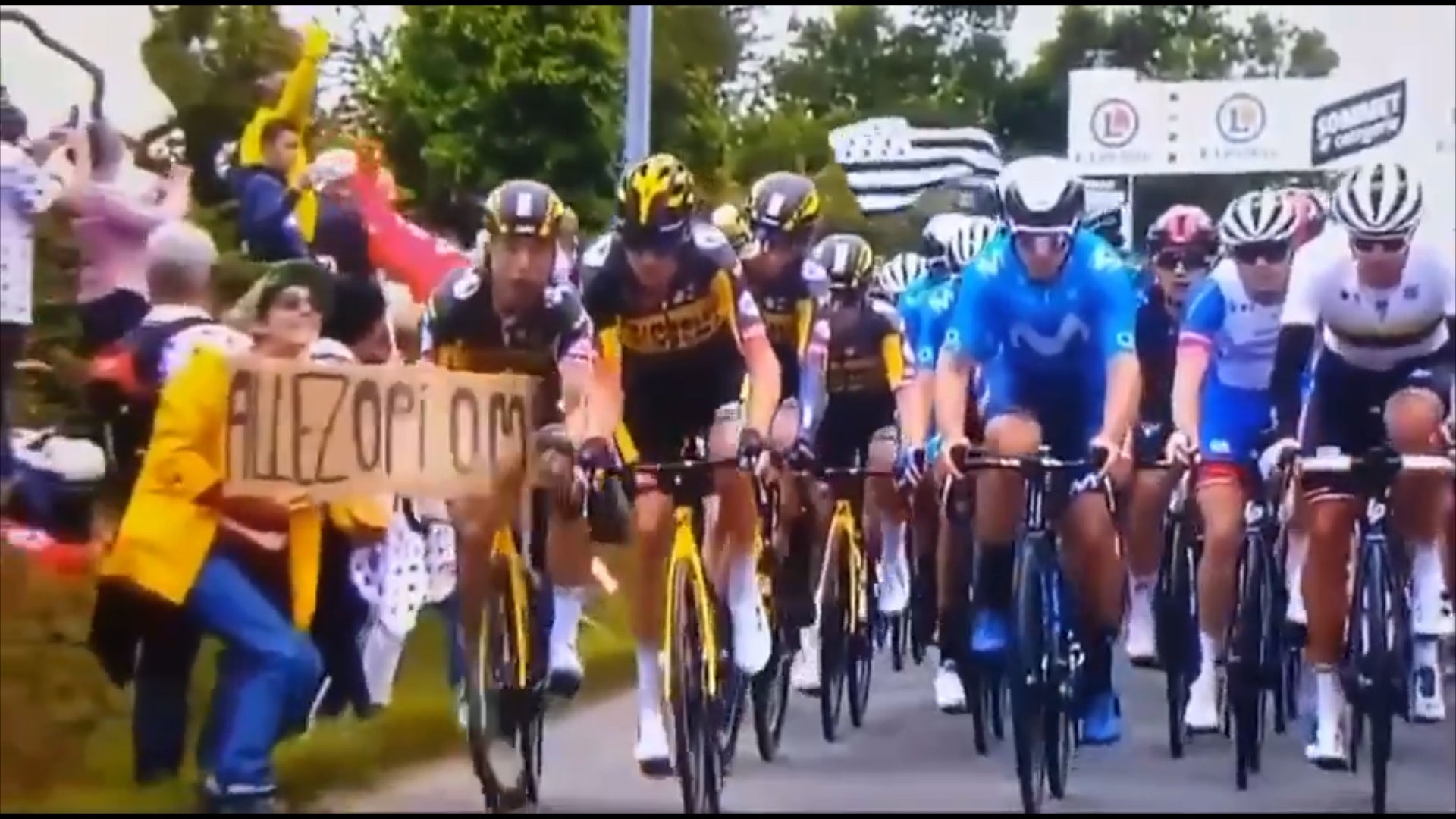 Tony Martin, left, rides into a fan’s banner