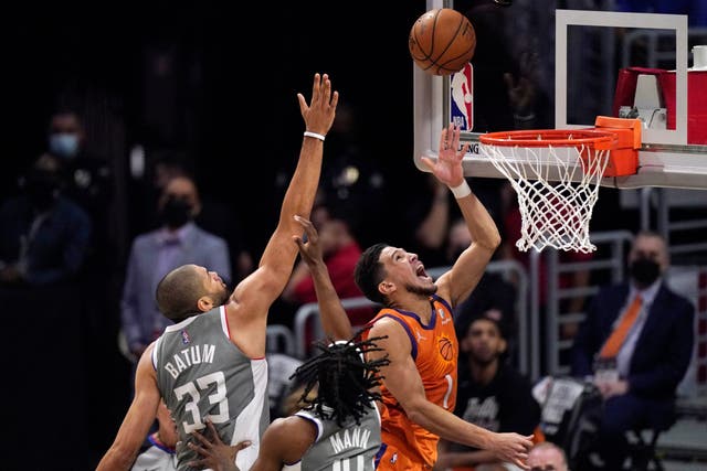 <p>Phoenix Suns guard Devin Booker, right, shoots as Los Angeles Clippers forward Nicolas Batum defends</p>