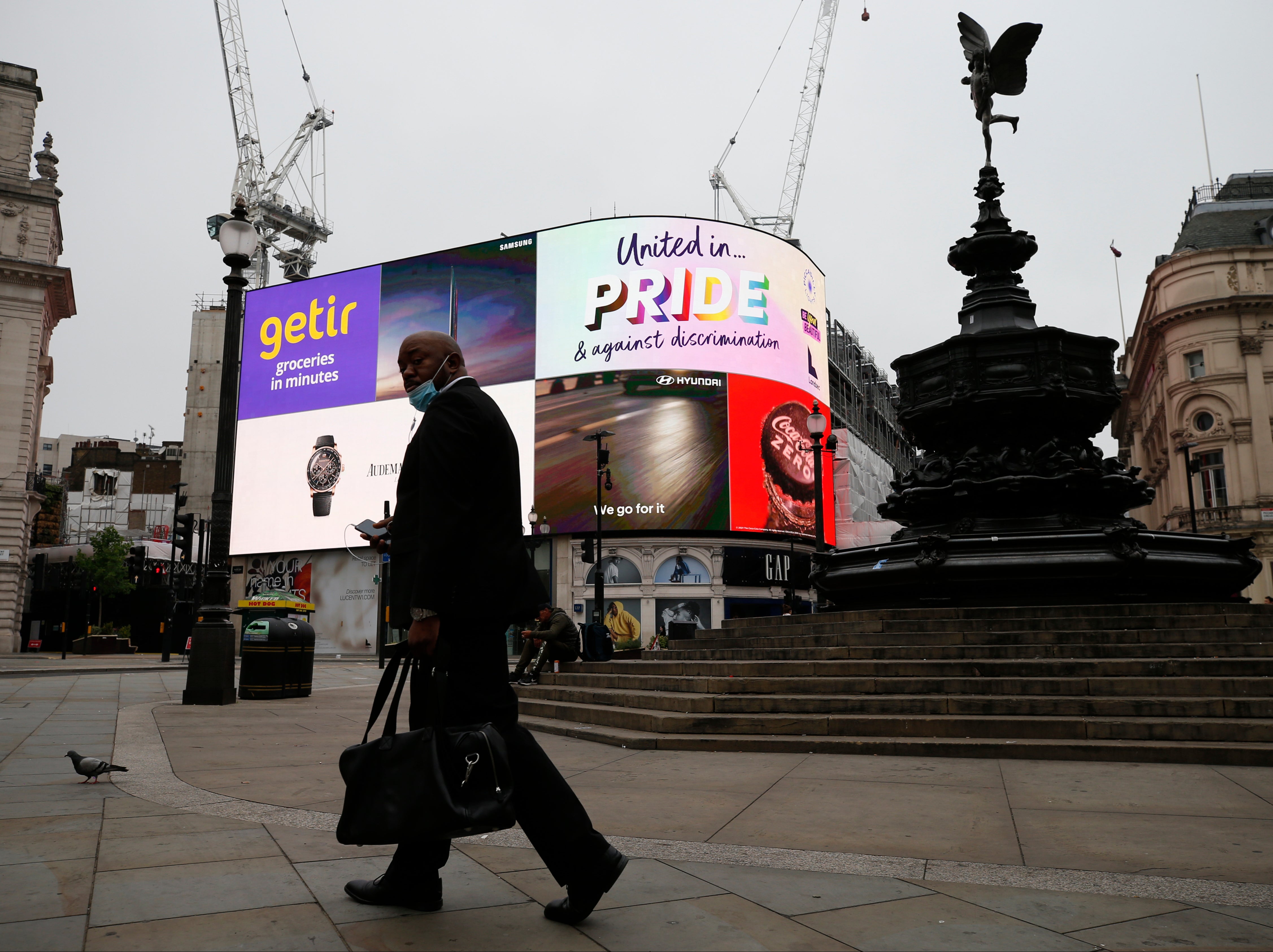 One man and his pigeon: an almost deserted Piccadilly Circus in central London on Sunday