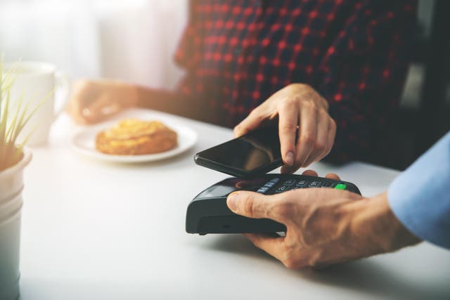 <p>Making a contactless payment with a phone</p>