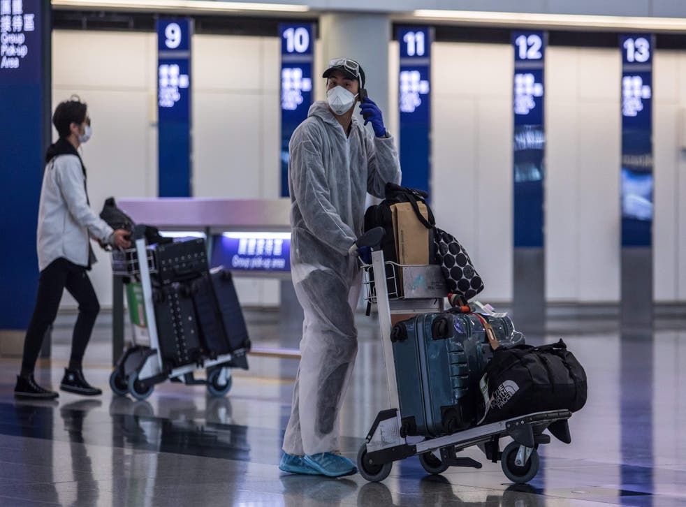 <p>File: A passenger wearing a face mask and protective suit at the Hong Kong International Airport on 4 April, 2020</p>