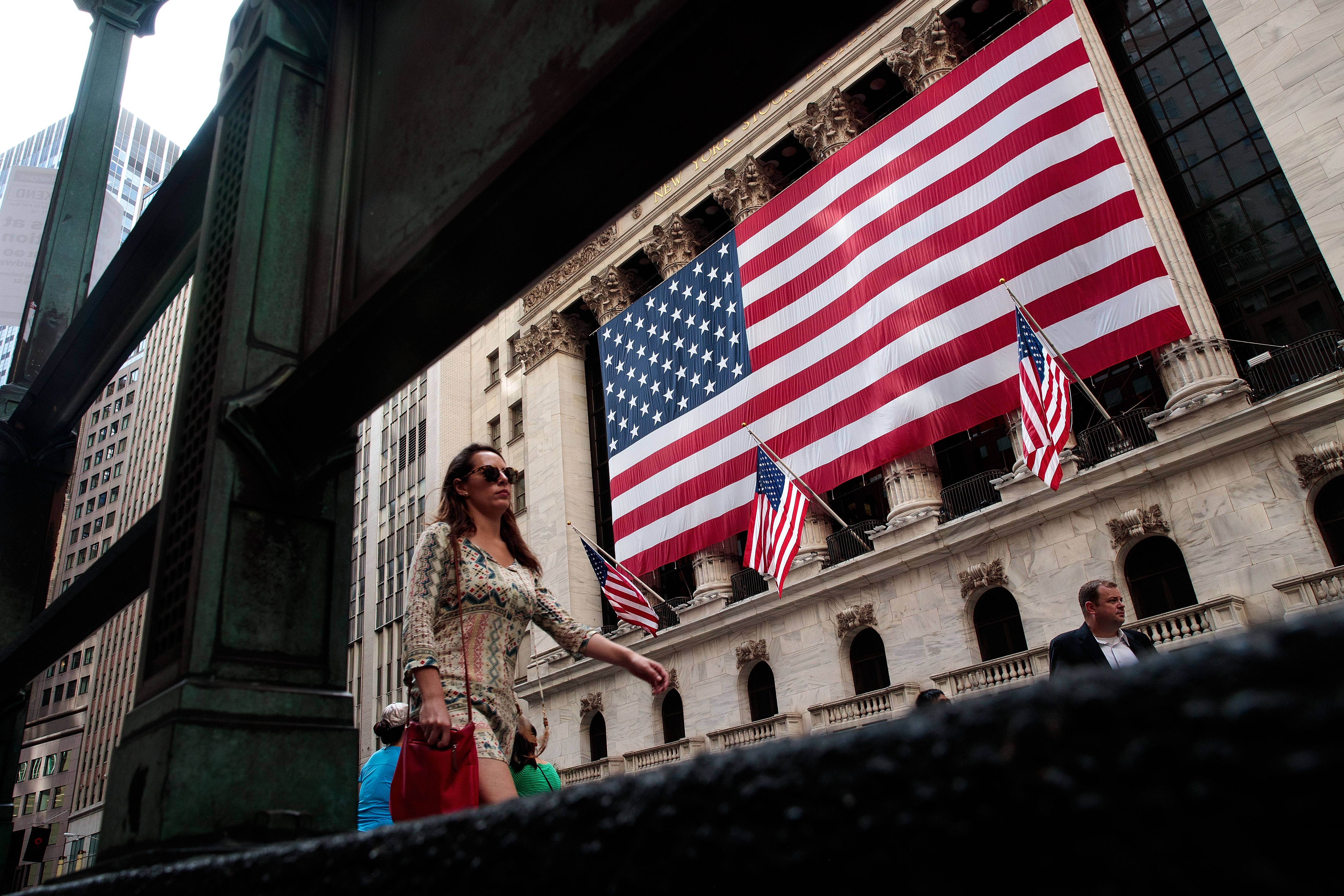 <p>People walk past the New York Stock Exchange (NYSE), 13 September, 2016 in New York City. </p>