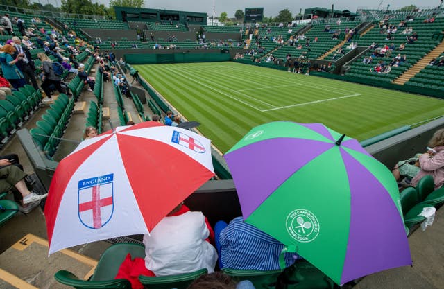 Fans shelter from the rain