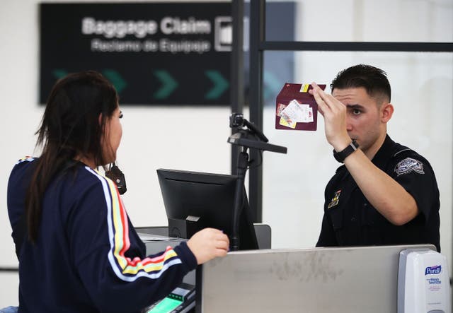 <p>A US Customs and Border Protection officer uses facial recognition technology in his booth at Miami International Airport to screen a traveler entering the United States on 27 February, 2018 in Miami, Florida. TSA has screened the highest number of travellers since March, 2020.</p>