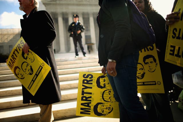 <p> Holding signs with images of murdered Mississippi civil rights workers James Earl Chaney, Andrew Goodman, and Michael Schwerner, demonstrators rally in front of the US Supreme Court on 27 February, 2013 in Washington, DC. Previously sealed files on the 1964 killings of the three men have been released for public viewing.</p>