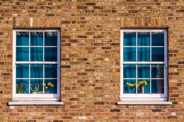 Two windows, with curtains drawn, in a north London street.