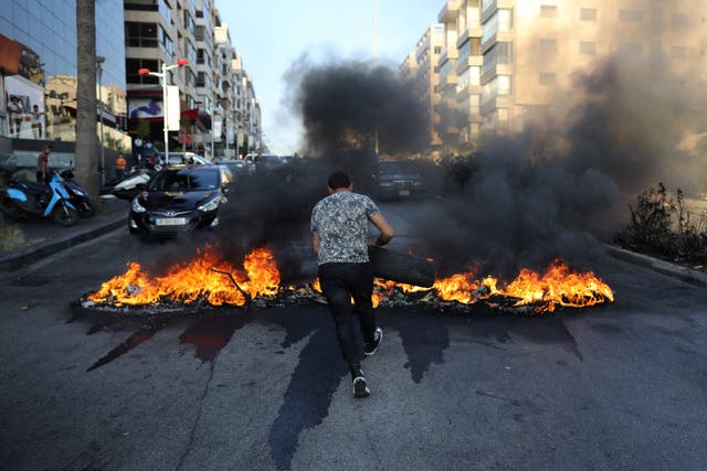 <p>A Lebanese man sets tires on fire during ongoing protests against fuel and energy shortages in Beirut</p>