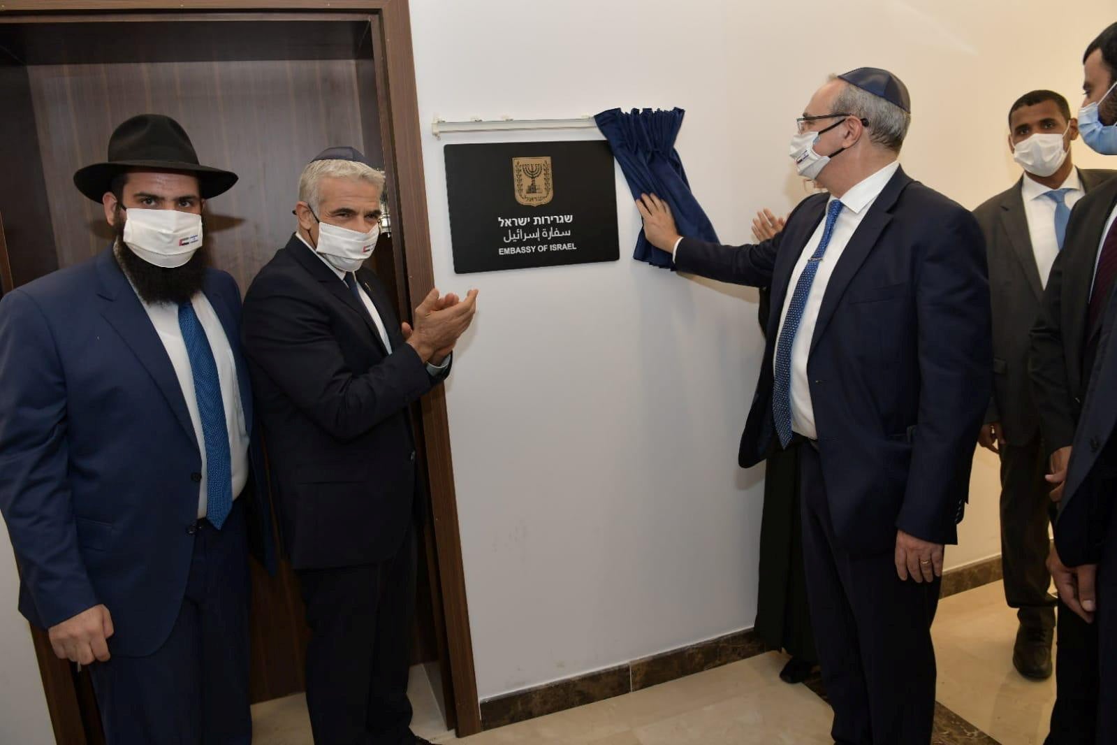 Israeli Foreign Minister Yair Lapid applauds as a plaque is revealed during an inauguration ceremony of Israel's embassy in Abu Dhabi, United Arab Emirates, on Tuesday