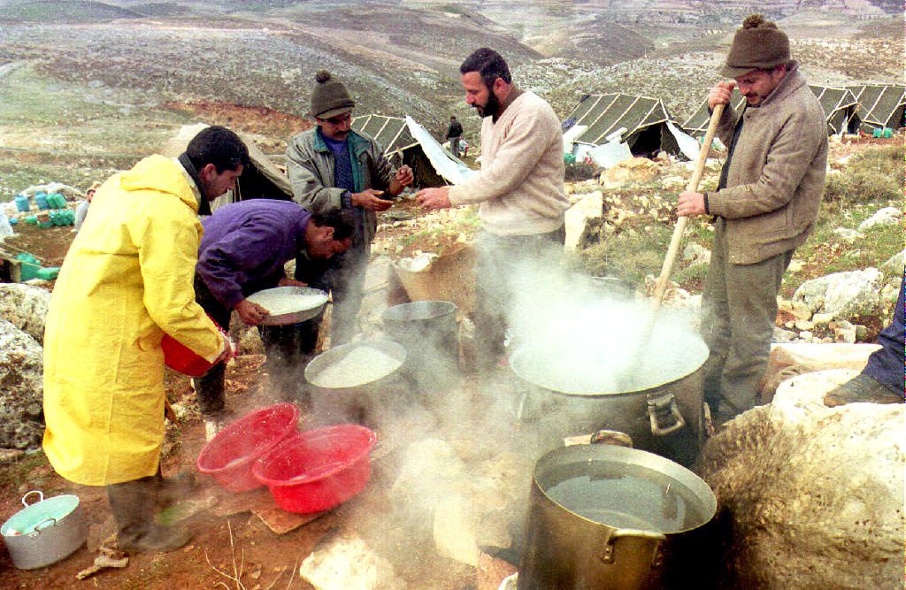 Deportees prepare food after returning to the camp