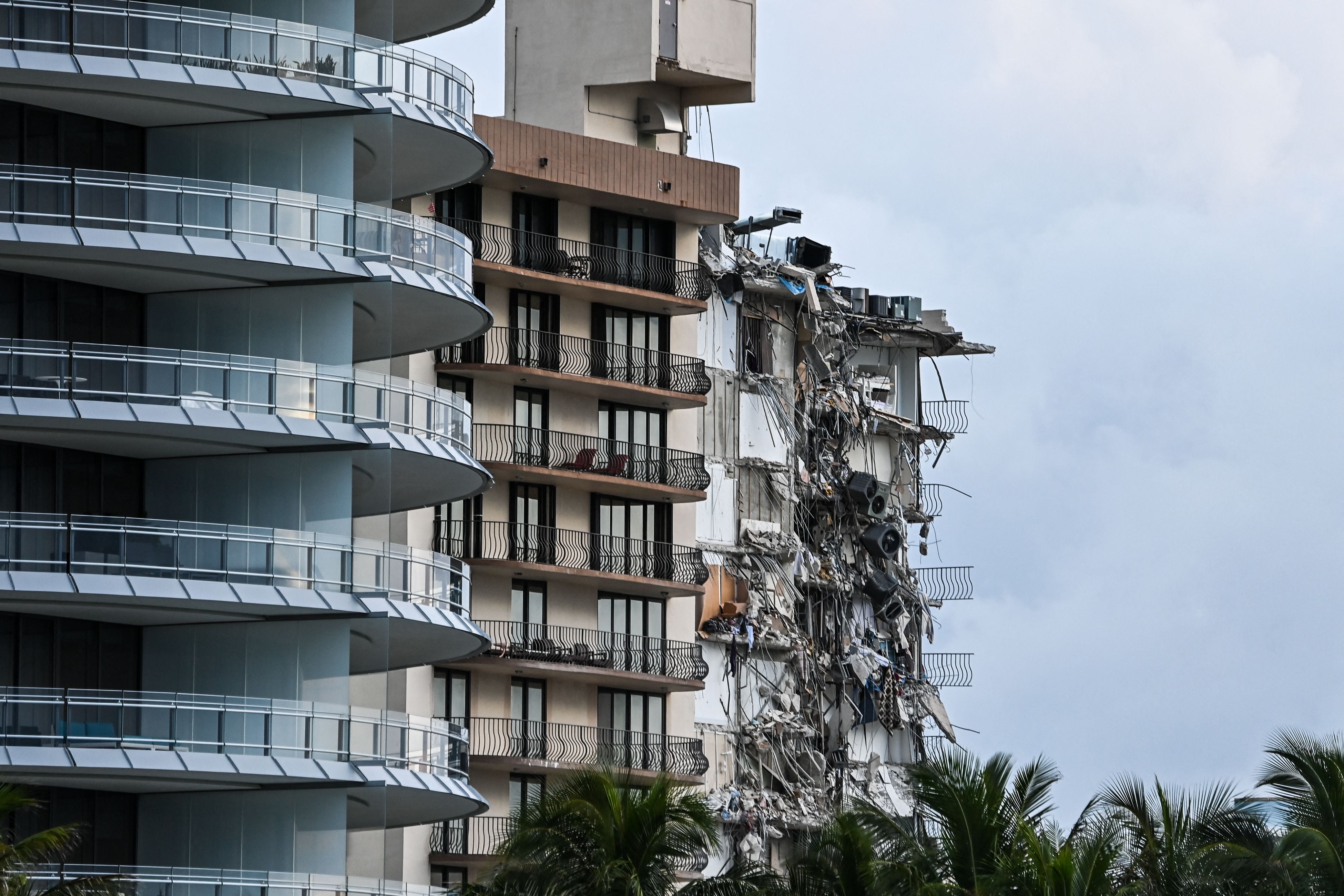 Rubble hangs from a partially collapsed building in Surfside north of Miami Beach, on 24 June 2021