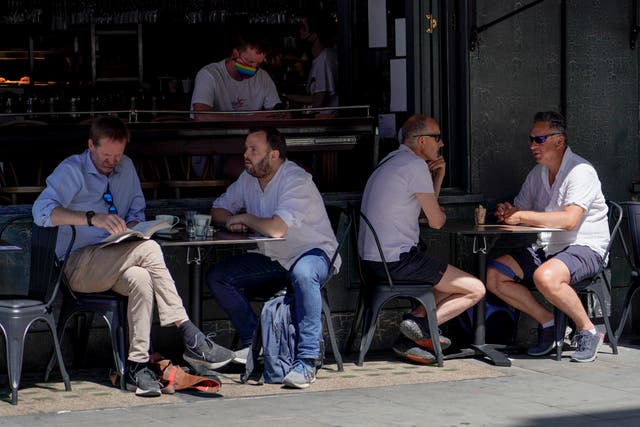 <p>People sit at outdoor tables at a restaurant in Soho, in London, last week</p>