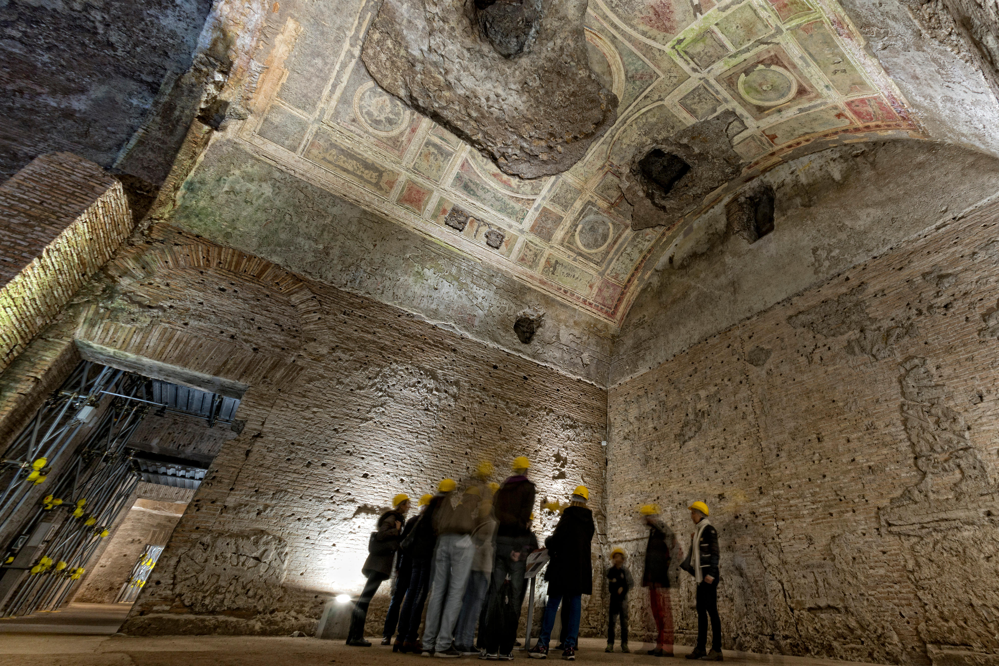 people exploring antique roman ruins being restored