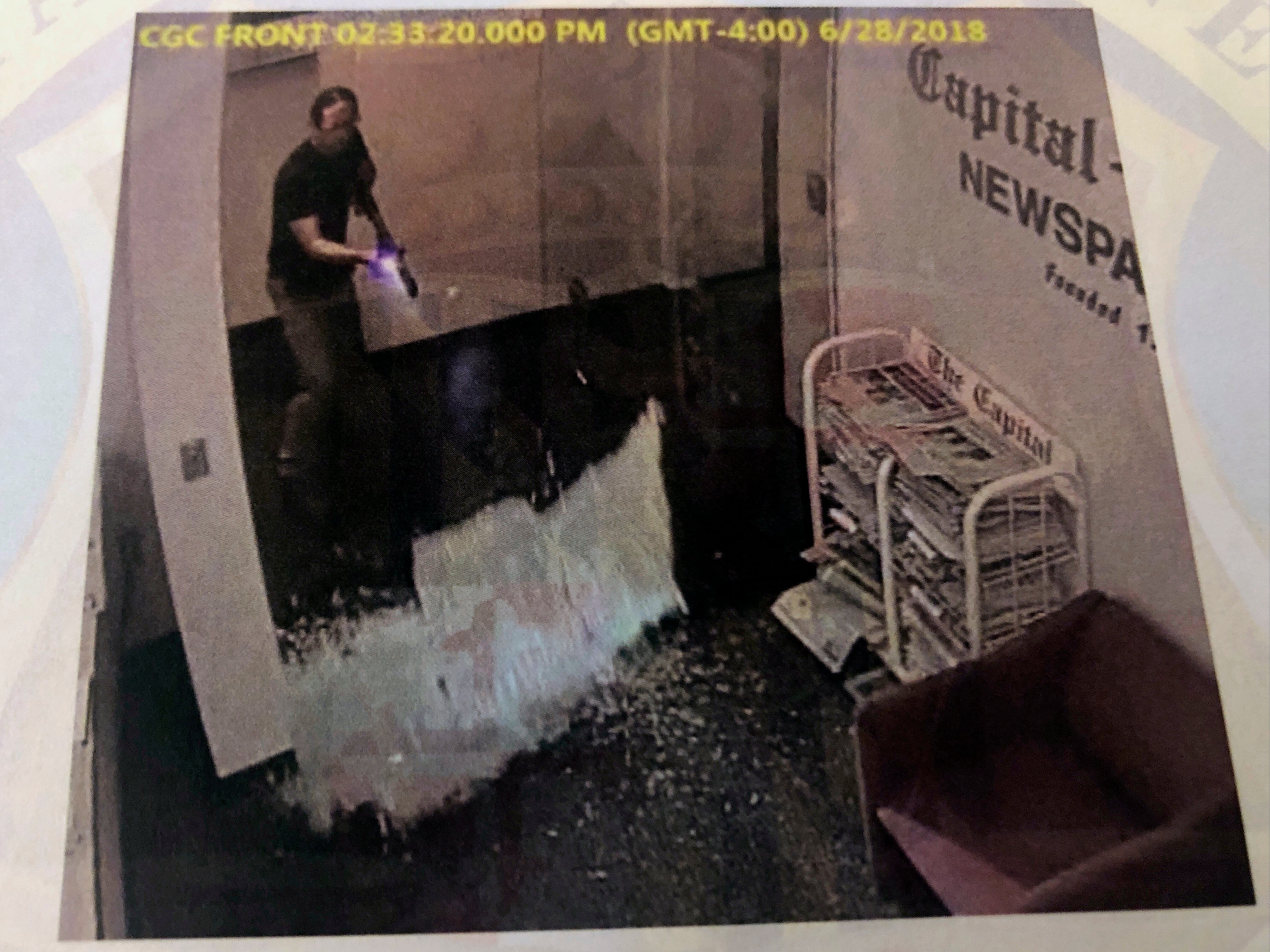 This photograph of an image in court evidence made public on Tuesday, June 29, 2021, from surveillance video, shows what authorities say is Jarrod Ramos shooting open the door of the Capital Gazette office on June 28, 2018, in Annapolis, Md.