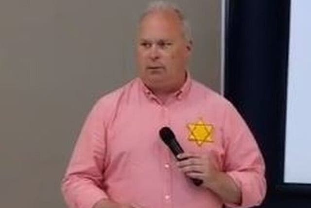 <p>Washington State Representative Jim Walsh wearing a yellow Star of David to complain about vaccine mandates during a speech. </p>