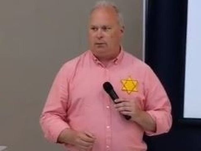 <p>Washington State Representative Jim Walsh wearing a yellow Star of David to complain about vaccine mandates during a speech. </p>