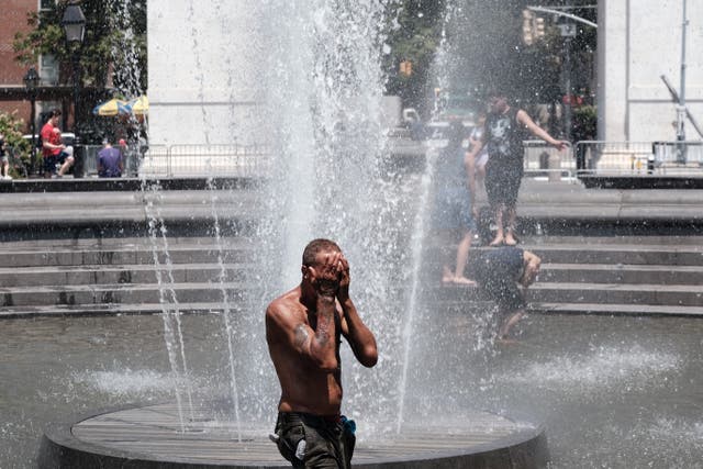 <p>New Yorkers cool off in Washington Square Park on 30 June as temperatures approach 100 degrees Fahrenheit during a bicoastal heat wave.</p>