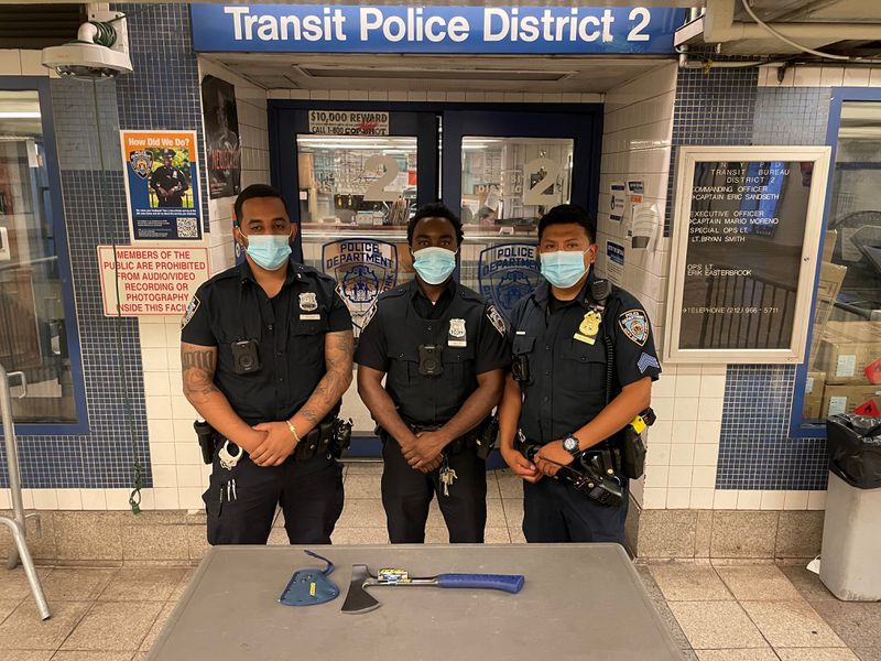 NYPD officers show the axe that suspect Steve Hunt allegedly brandished on a New York subway train