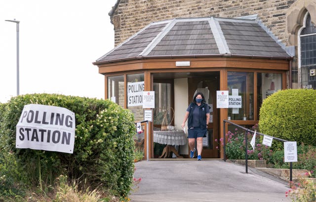 <p>A voter leaves Norristhorpe United Reformed Church polling station in the West Yorkshire constituency of Batley and Spen</p>