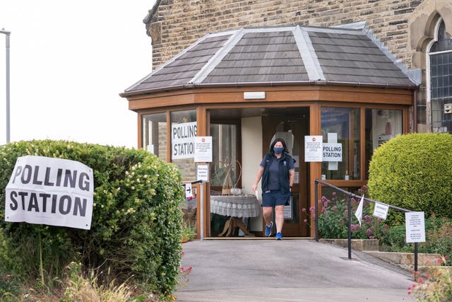 <p>A voter leaves Norristhorpe United Reformed Church polling station in the West Yorkshire constituency of Batley and Spen</p>