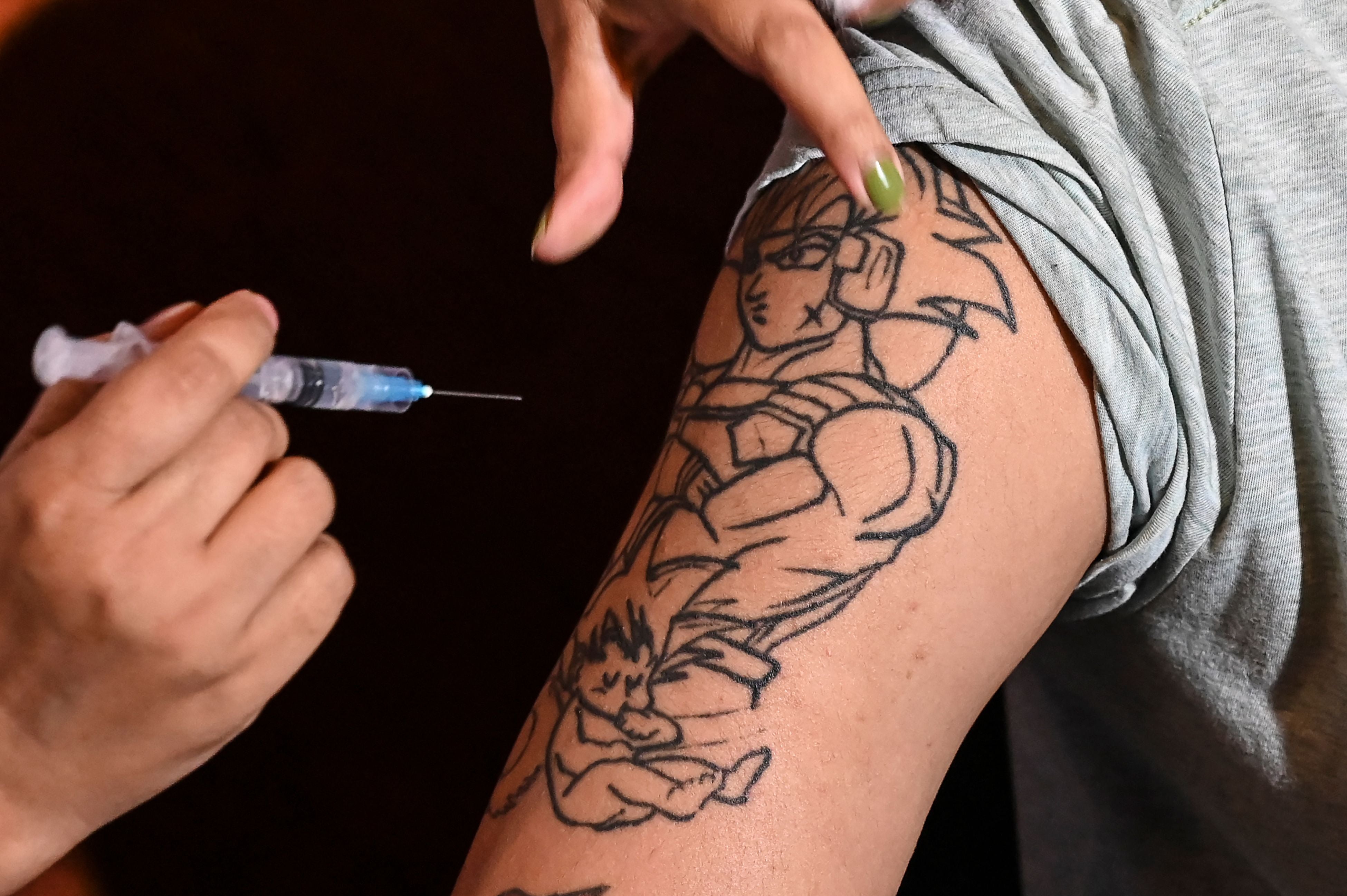 A health worker inoculates a hotel employee with a dose of the Covishield vaccine against the Covid-19 coronavirus inside a hotel in Kolkata, India