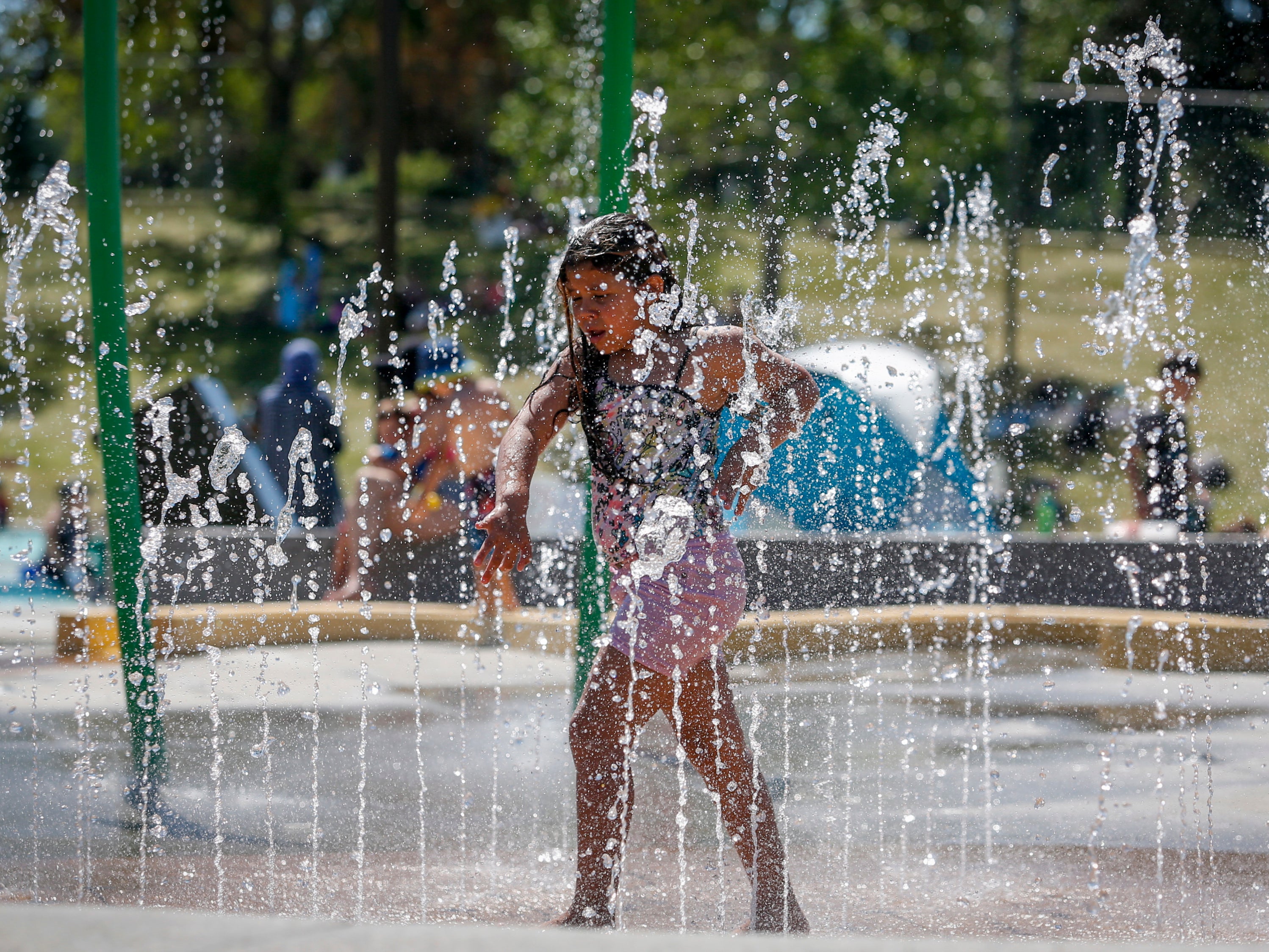 A girl runs through a fountain in Alberta, Canada