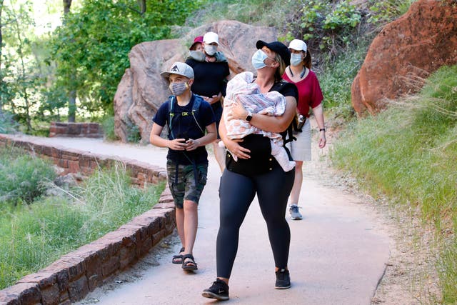 <p>Excursionistas enmascarados caminan por un sendero pavimentado a lo largo del North Fork del Virgin River en el Parque Nacional Zion el 15 de mayo de 2020 en Springdale, Utah. El estado ha visto un aumento en los casos de la variante Delta.</p>