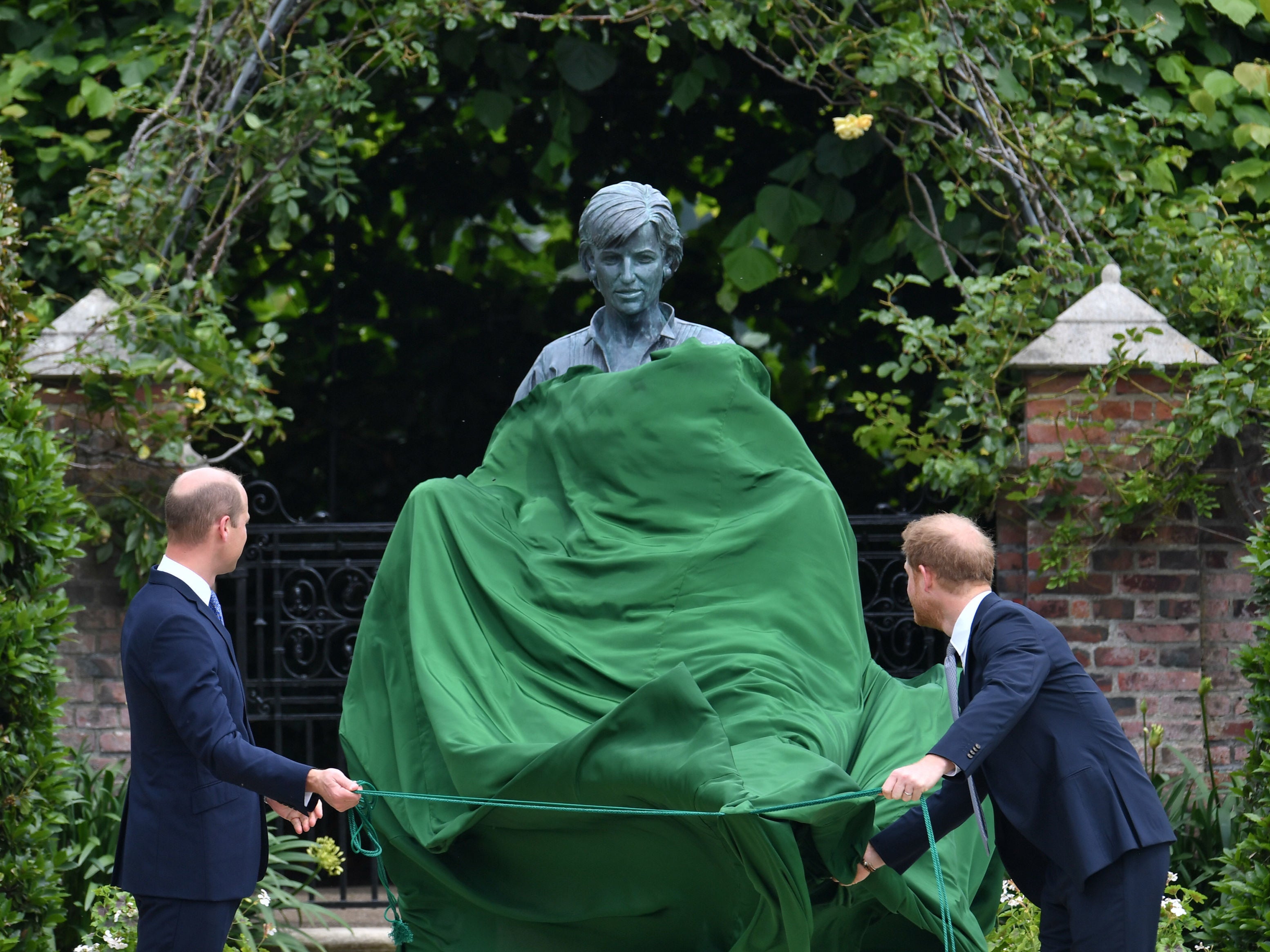 The Duke of Cambridge (left) and Duke of Sussex look at a statue they commissioned of their mother Diana