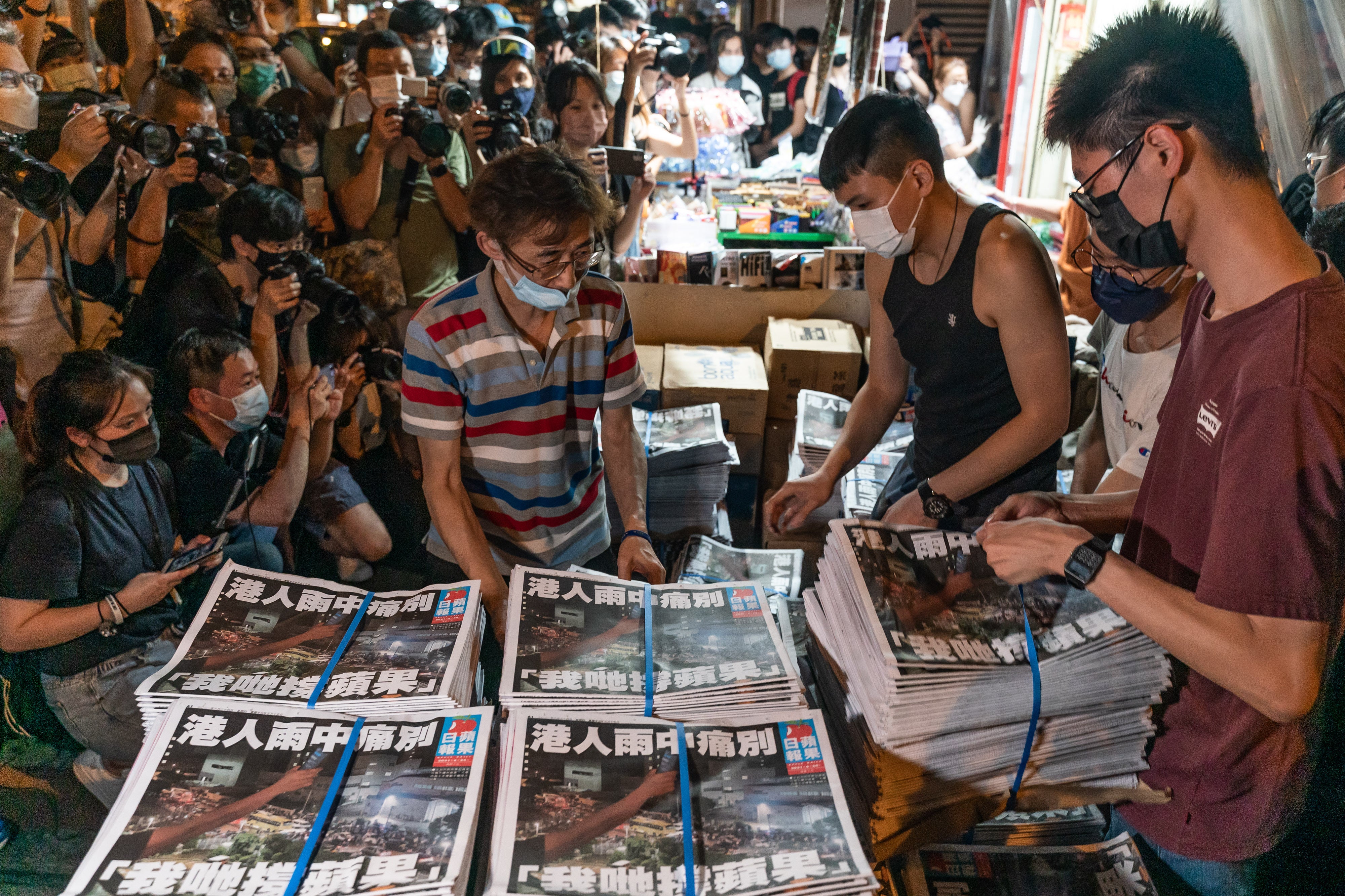 Hundreds braved heavy rain and gathered outside the Apple Daily office to get the pro-democracy newspaper’s final edition on 24 June