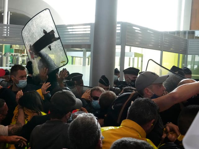 <p>Protesters scuffle with French police in front of the passport control of Terminal 2E of Charles de Gaulle Airport in Paris</p>