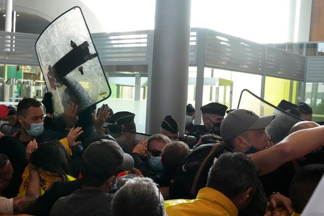<p>Protesters scuffle with French police in front of the passport control of Terminal 2E of Charles de Gaulle Airport in Paris</p>