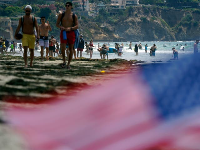 <p>ARCHIVO - En esta foto de archivo del 1 de julio de 2021, la gente camina por la playa de La Jolla Shores mientras se acerca el fin de semana del Día de la Independencia en San Diego. Se espera que los estadounidenses que disfrutan de una libertad recién descubierta viajen y se reúnan para comidas al aire libre, fuegos artificiales y reuniones familiares durante el fin de semana del 4 de julio en números no vistos desde los días previos a la pandemia. (Foto AP / Gregory Bull, archivo)</p>