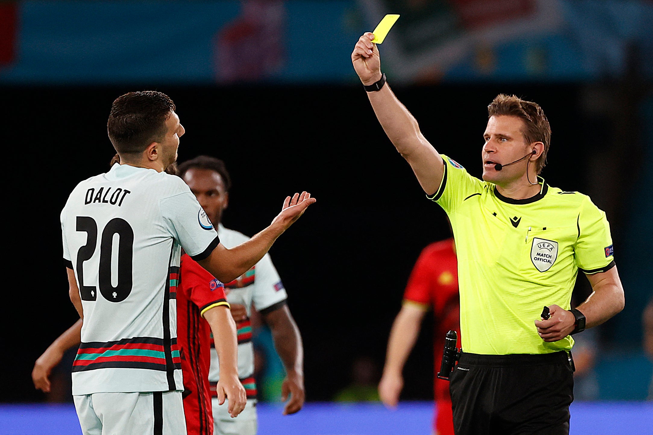 German referee Felix Brych presents a yellow card to Diogo Dalot