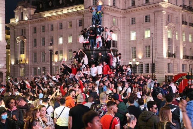 <p>Fans seen climbing the Shaftesbury memorial fountain in Piccadilly Circus, following England’s win against Ukraine</p>