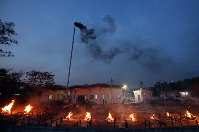 <p>File: Smoke billows from a chimney of an electric crematorium as burning pyres of Covid-19 victims are seen at a crematorium in Bhopal on 23 April, 2021</p>