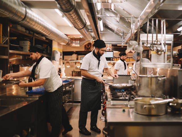 <p>Equipo de cocina de restaurante preparando comida</p>