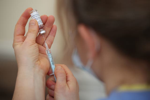 <p>A nurse prepares a shot with the Covid-19 vaccine.</p>