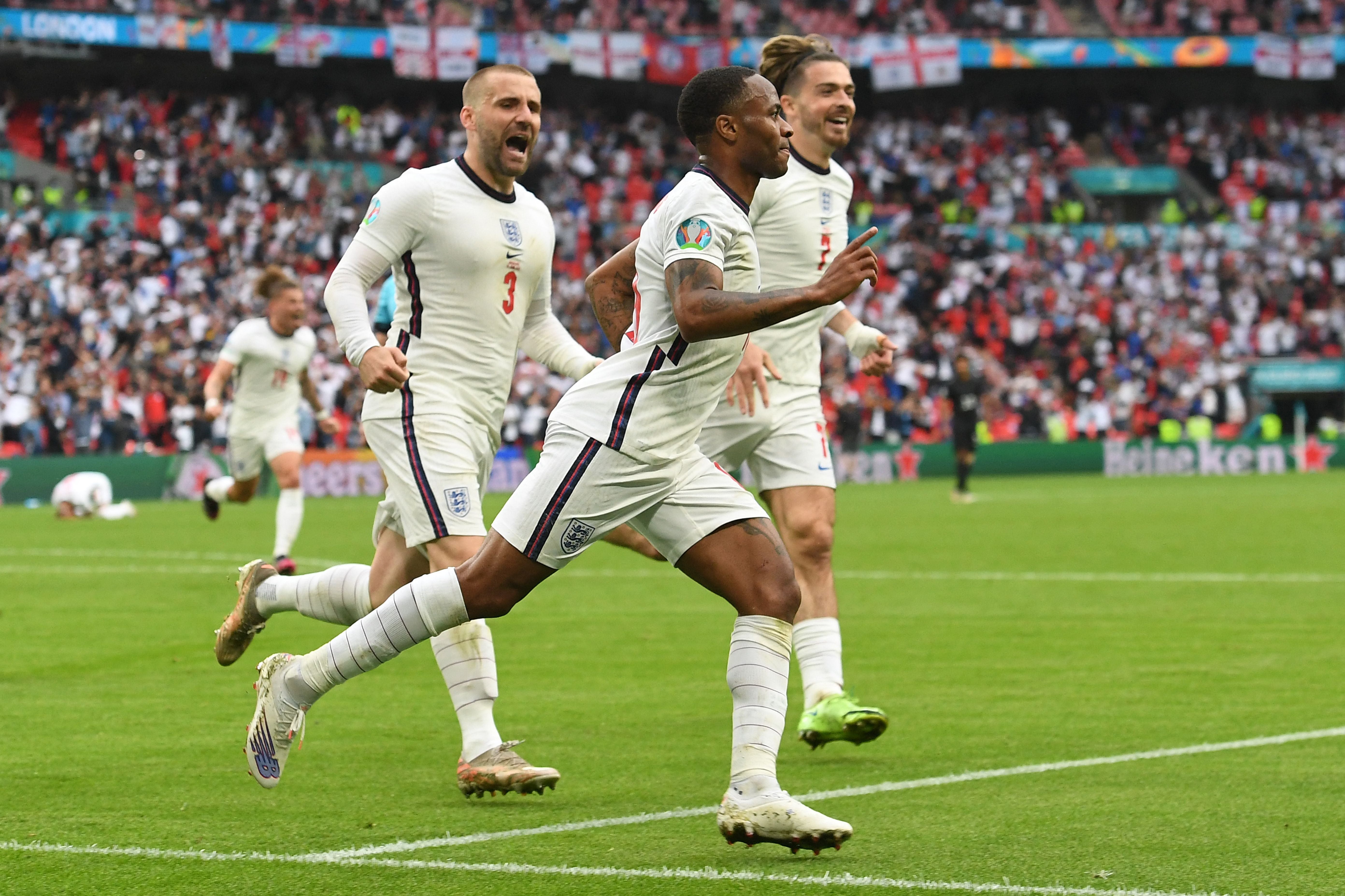 Sterling celebrates with Luke Shaw (left) and Jack Grealish after scoring against Germany