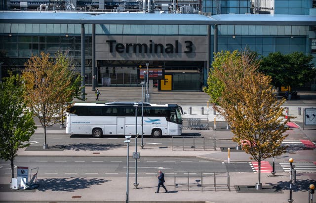 <p>A bus used to transport red list arriving airline passengers passes the Terminal 3 building at Heathrow Airport </p>