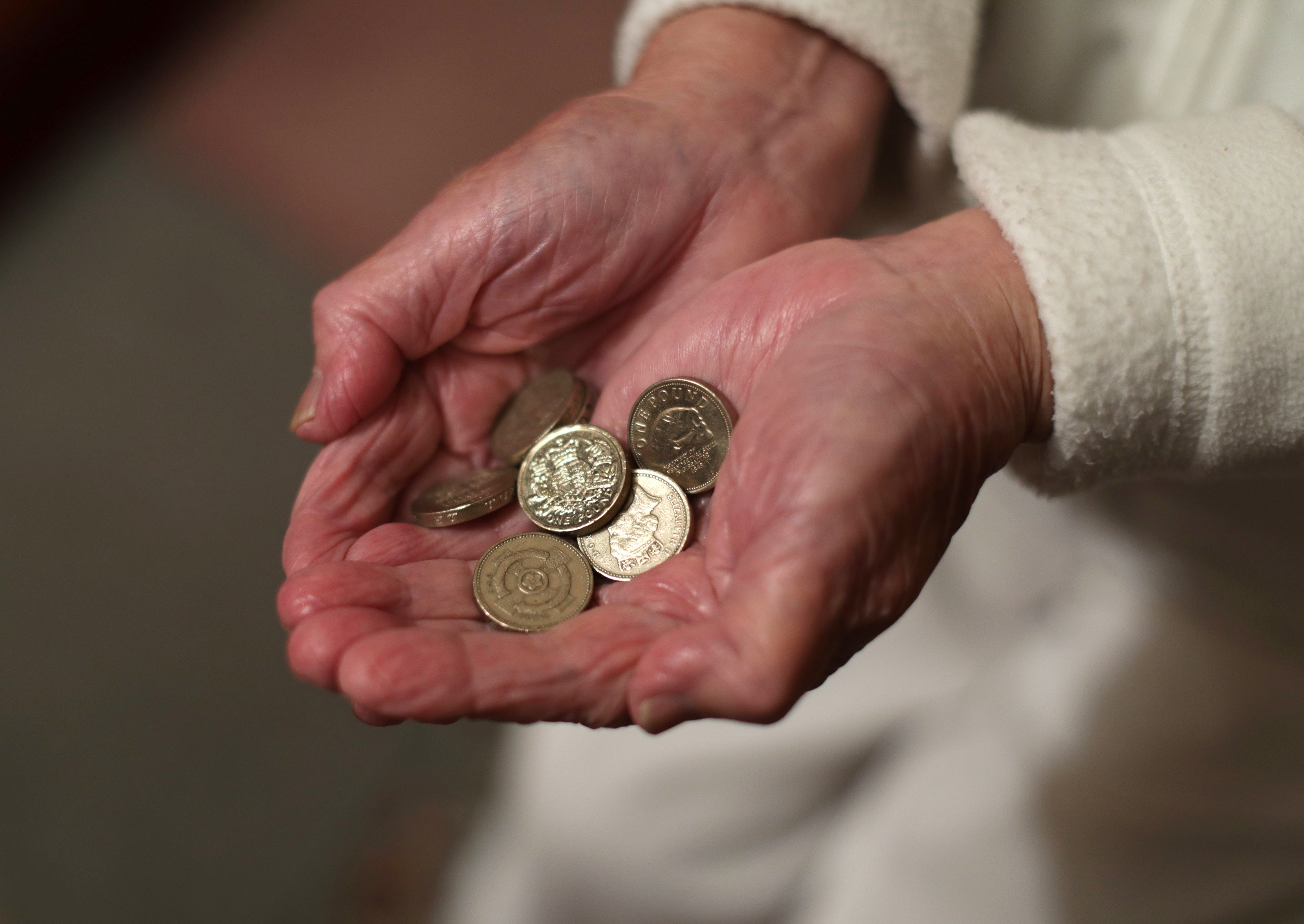 Elderly person holding coins