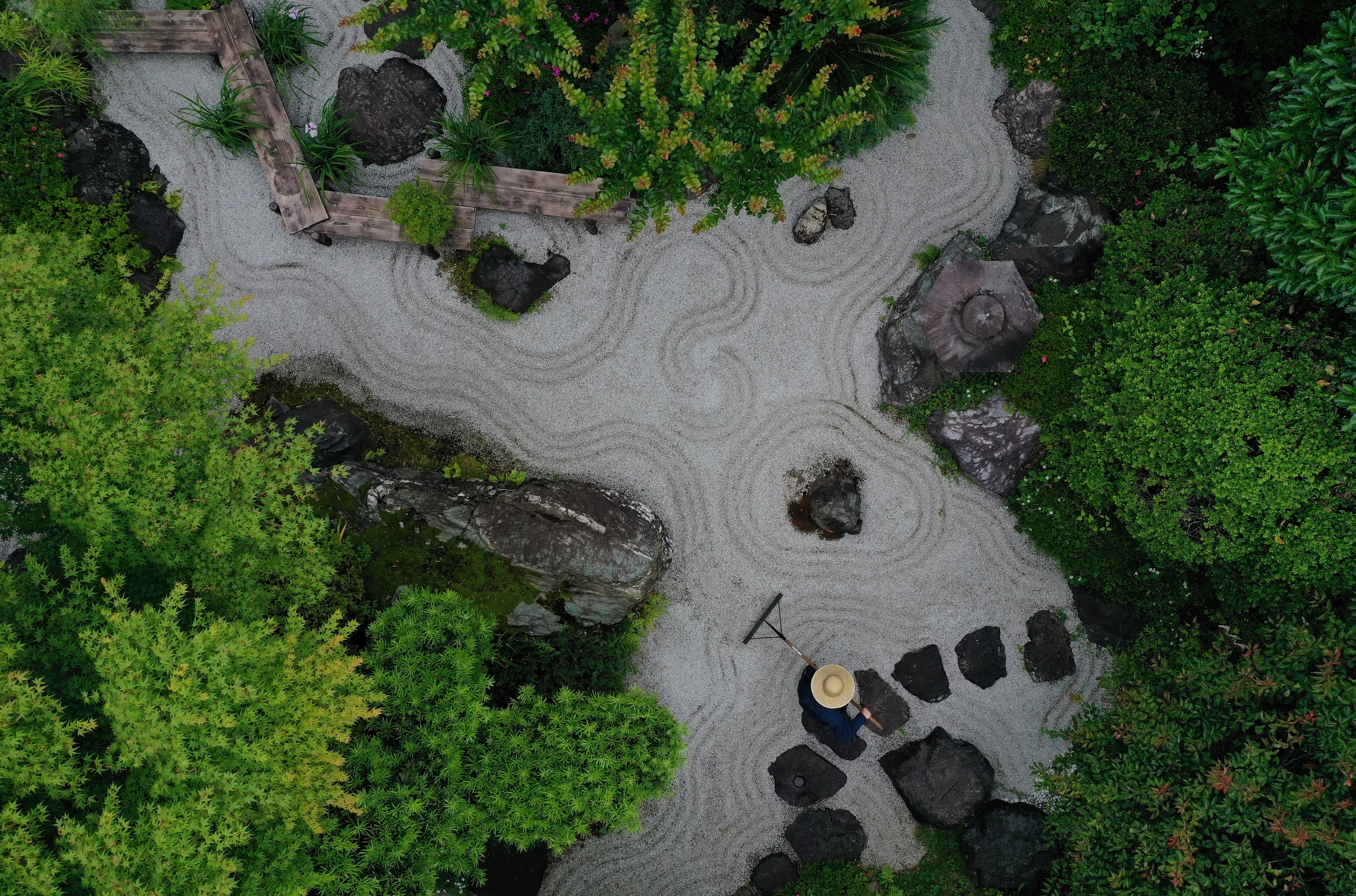 A gardener makes wave-shaped patterns, known as ‘samon’, at Karesansui, a traditional Japanese Dry Landscape, at Takao Komagino Garden in Hachioji, on the outskirts of Tokyo