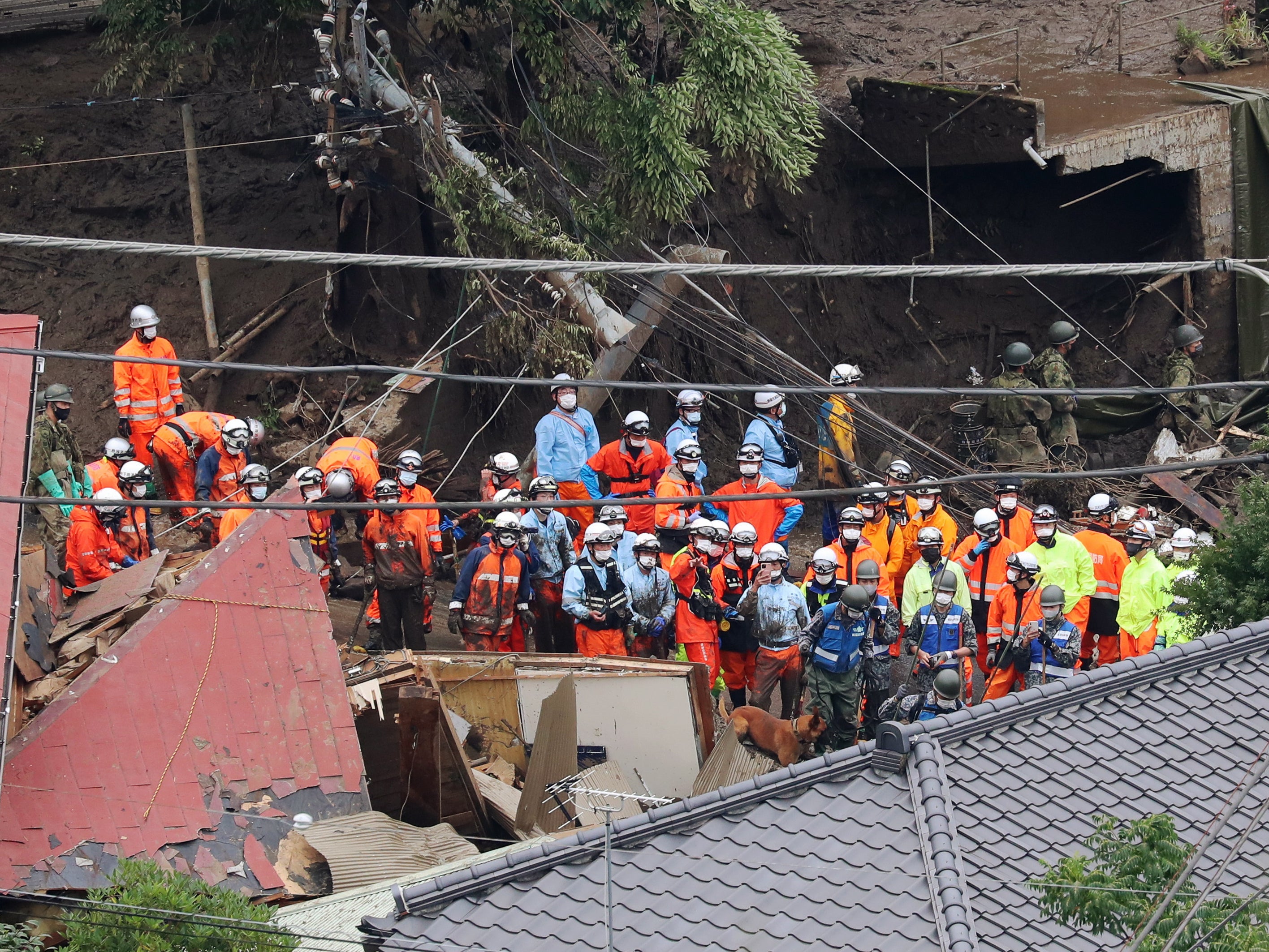 <p>Police and firefighter rescuers are searching for missing people in Atami</p>