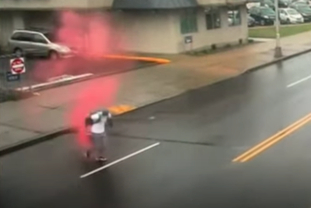 <p>Surveillance footage shows the moment a suspected bank robber is enveloped in pink smoke from a dye pack</p>