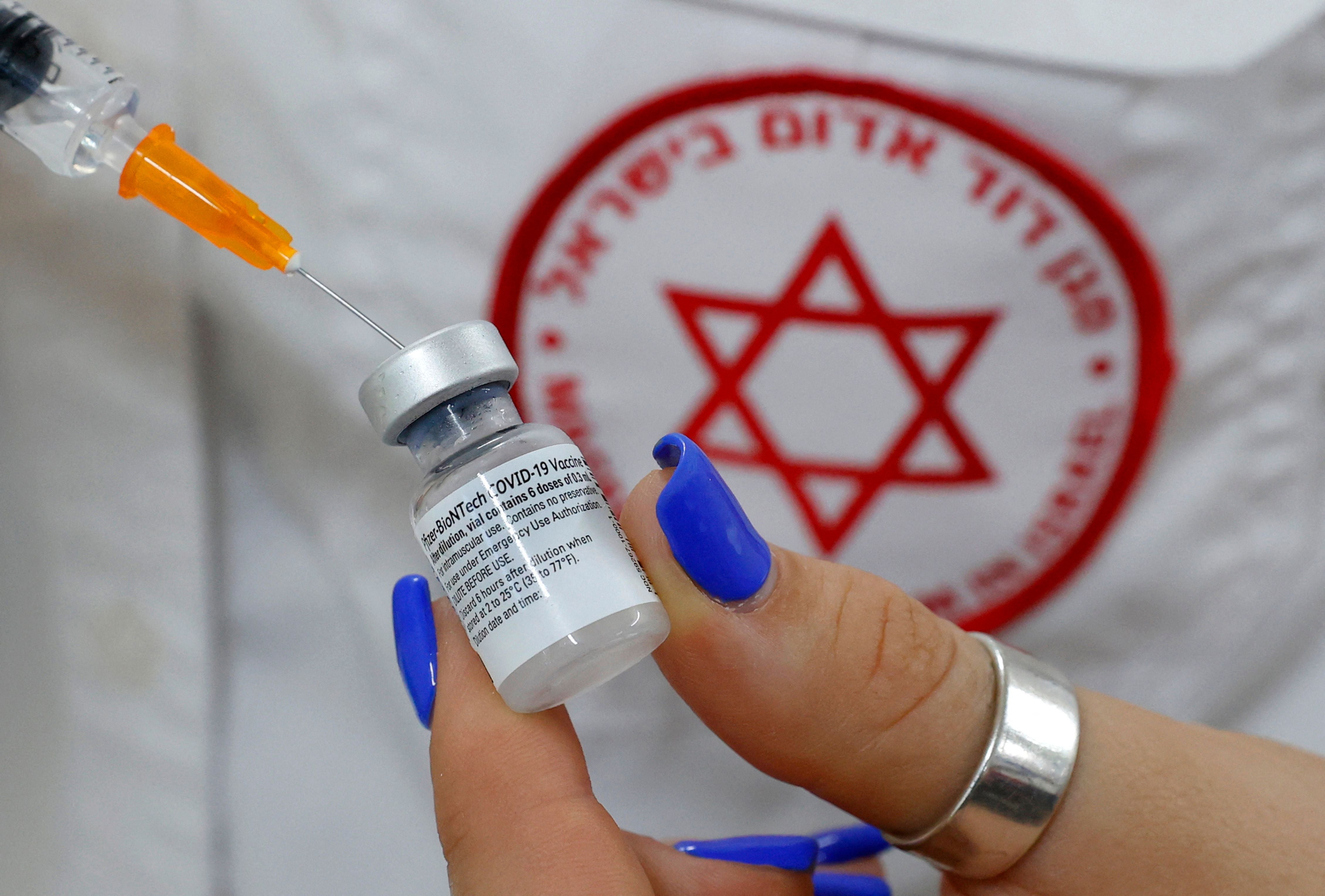 <p>An Israeli medical worker prepares a dose of the Pfizer/BioNTech Covid-19 vaccine </p>
