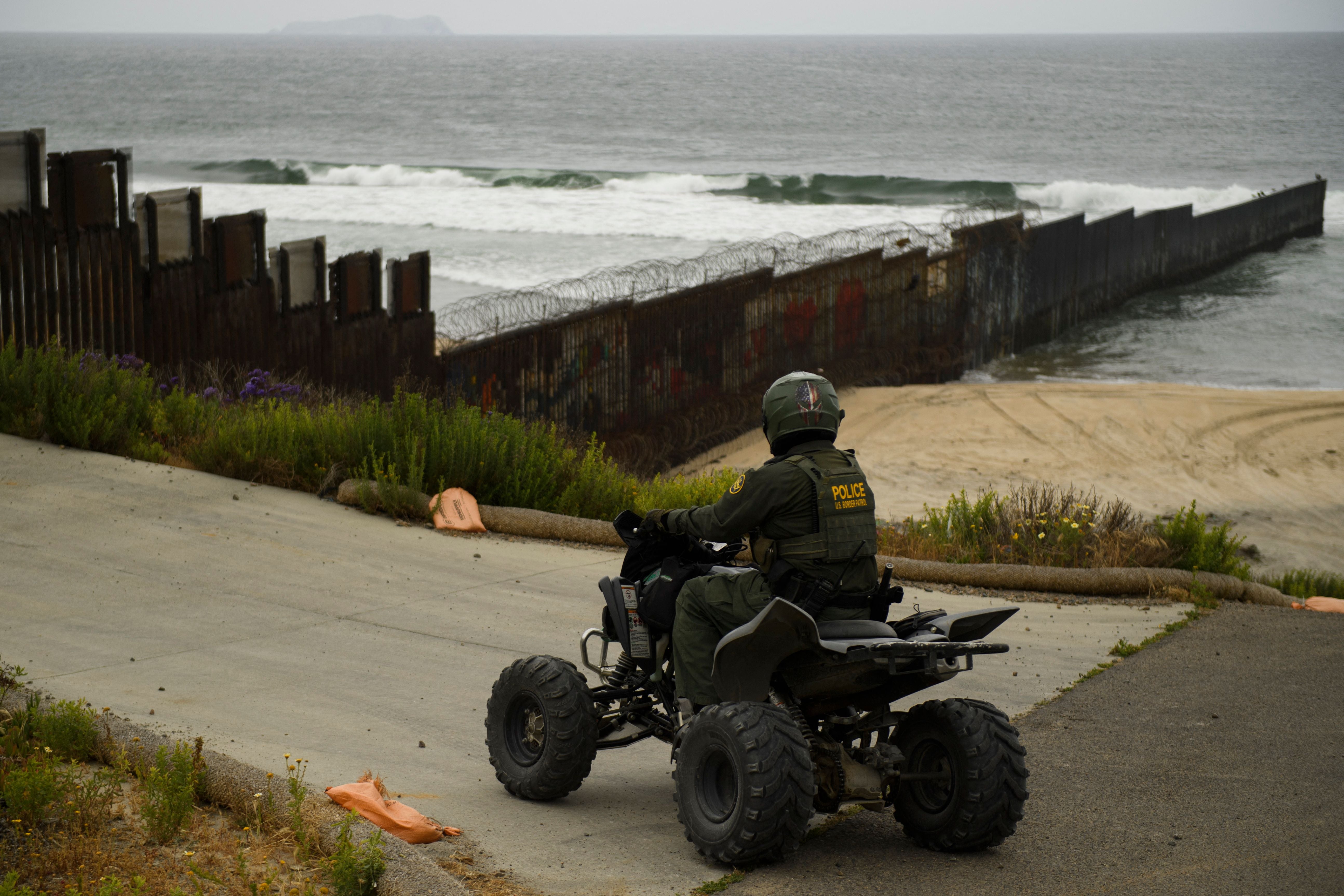 A US Border Patrol agent patrols on an all-terrain vehicle where the border wall ends in the Pacific Ocean along the US-Mexico border between San Diego and Tijuana, during a tour with the US Customs and Border Protection on May 10, 2021 at International Friendship Park in San Diego County, California.