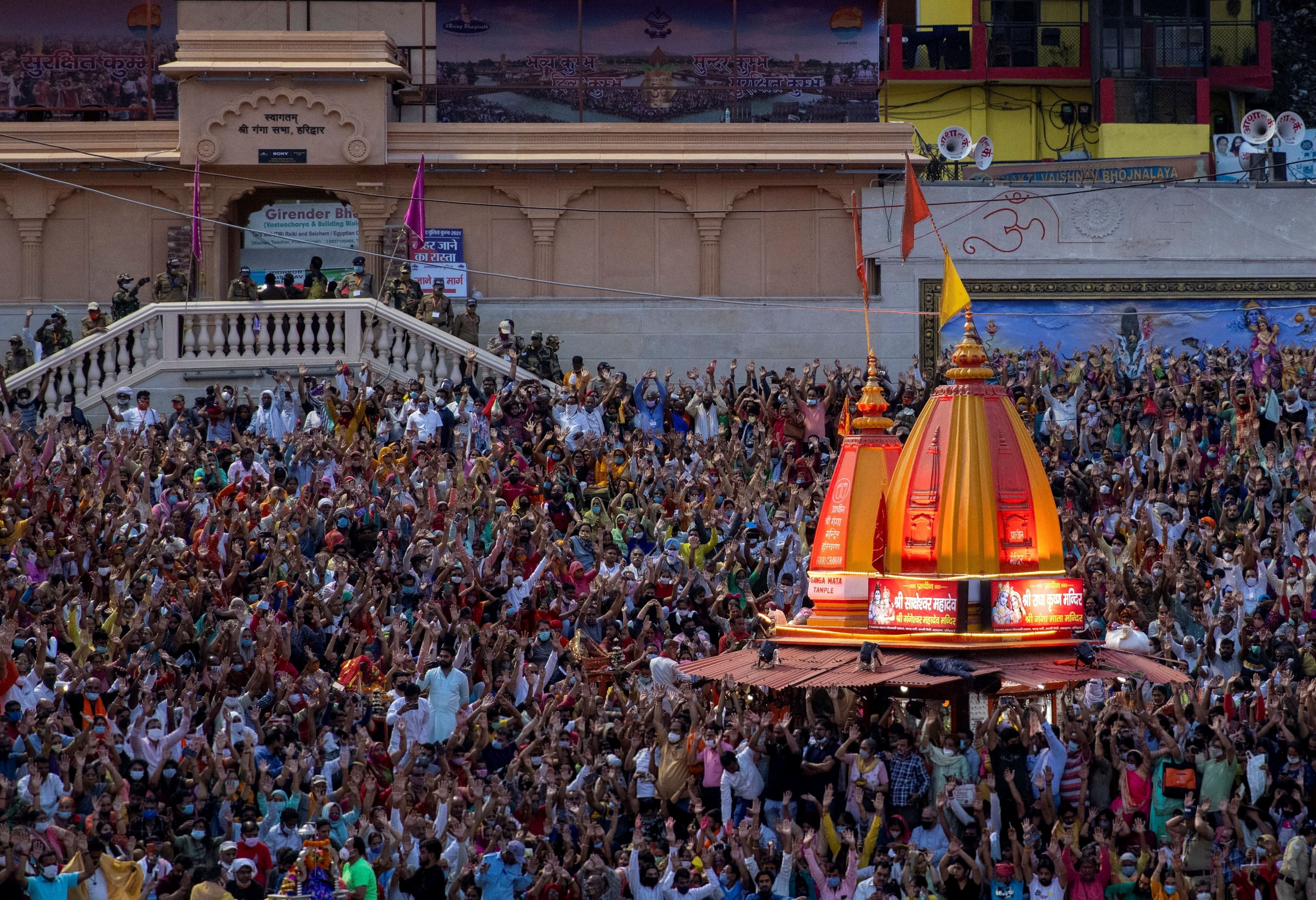 Devotees gather for an evening prayer on the banks of Ganges river during Kumbh Mela on 11 April