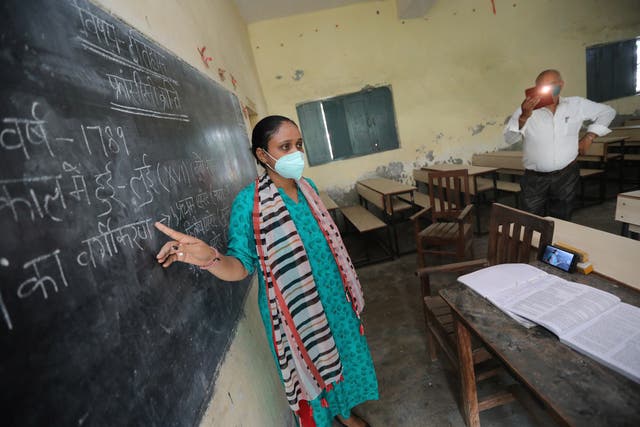 <p>A teacher at Gandhi Smarak school in Raghunathpur near New Delhi records a history lesson via mobile phone for students</p>