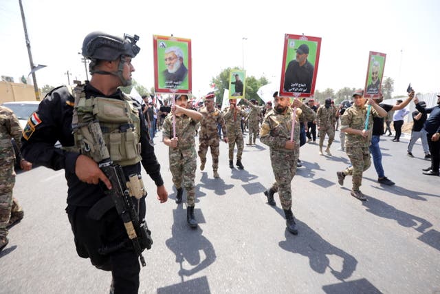<p>Supporters of Iran-backed Iraqi Shiite Popular Mobilization Forces carry the pictures of their comrades who were killed in a US airstrike near the Iraqi border last month</p>